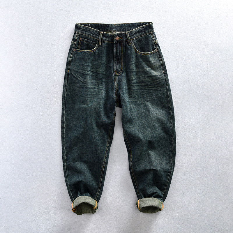 Dark-green washed jeans with tan contrast seams, front pockets and rolled hems.