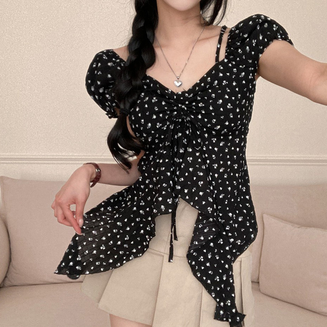 Black floral puff-sleeve asymmetrical top. Supplier product photograph.